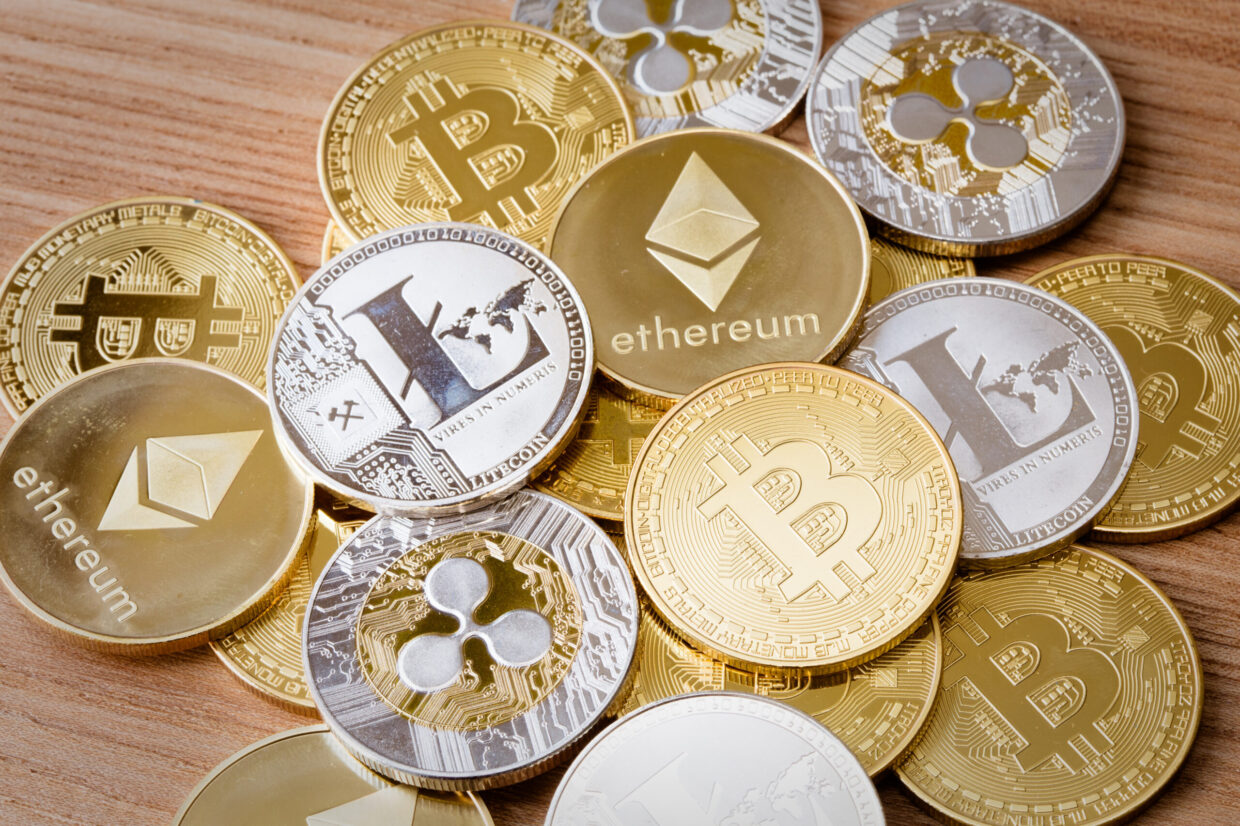 A group of crypto currency coins including Bitcoin, Litecoin, Ripple and Ethereum on an isolated background